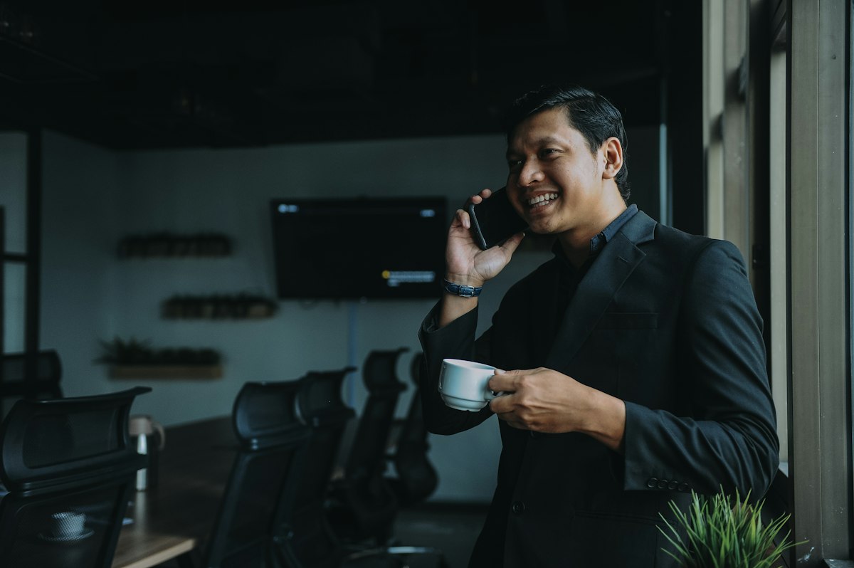 A professional on a phone call in a dark modern office