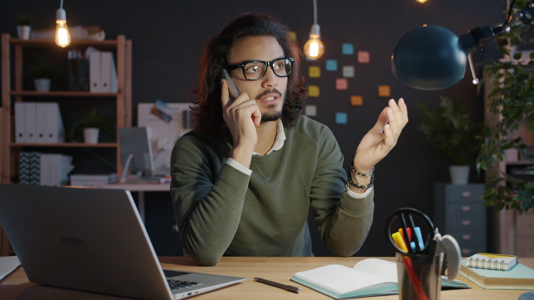 A sales executive talking to a customer on the phone at his desk