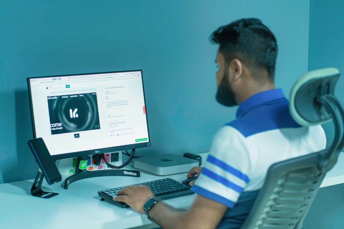 A professional at a desk with two screens, handling calls